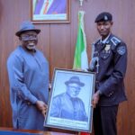 Gov Sheriff receiving a plaque from ASP Akpevwoghene Collins during the visit